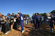 25 September 2018; Jon Rahm, left, and Rory McIlroy of Europe signs autographs on their way to the 14th tee box during a practice round ahead of the Ryder Cup 2018 Matches at Le Golf National in Paris, France. Photo by Ramsey Cardy/Sportsfile
