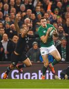 17 November 2018; Jacob Stockdale of Ireland on his way to scoring his side's first try despite the attempted tackle from Aaron Smith of New Zealand during the Guinness Series International match between Ireland and New Zealand at the Aviva Stadium in Dublin. Photo by David Fitzgerald/Sportsfile