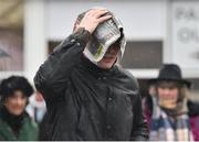 12 March 2019; A racegoer takes shelter under a newspaper as he arrives prior to racing on Day One of the Cheltenham Racing Festival at Prestbury Park in Cheltenham, England. Photo by Seb Daly/Sportsfile