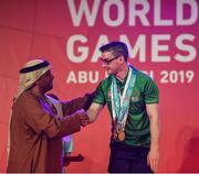 17 March 2019; Team Ireland's Patrick Quinlivan, a member of the Salto SOC from Letterkenny, Co. Donegal, receives the third of his seven medals for Artistic Gymnastics from H.H. Abdulla Bin Mohomed Al Hamed on Day Three of the 2019 Special Olympics World Games in the Abu Dhabi National Exhibition Centre, Abu Dhabi, United Arab Emirates. Photo by Ray McManus/Sportsfile