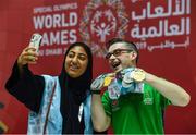 17 March 2019; Team Ireland's Patrick Quinlivan, a member of the Salto SOC from Letterkenny, Co. Donegal, who won seven medals, two Gold and five Silver, for Artistic Gymnastics poses with a local volunteer for a 'selfie' on Day Three of the 2019 Special Olympics World Games in the Abu Dhabi National Exhibition Centre, Abu Dhabi, United Arab Emirates. Photo by Ray McManus/Sportsfile
