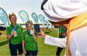 20 March 2019; Special Olympics Volunteer Mansoor Ali Aljaberi takes a photo of Team Ireland's Mairead Moroney, a member of the Ennis SOGC, from Ennis, Co. Clare, who has the distinction of being the oldest athlete at the Games, and her Alternate Shot Team Play Partner Jean Molony, left, after they had collected their Silver Medal in the Level 2 - Unified Alternate Shot Team Play Competition on Day Six of the 2019 Special Olympics World Games in Yas Links, Yas Island, Abu Dhabi, United Arab Emirates  Photo by Ray McManus/Sportsfile
