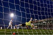 19 April 2019; Daniel Grant of Bohemians shoots to score his side's third goal, despite the attempts of Conor Kearns and Liam Scales of UCD, during the SSE Airtricity League Premier Division match between Bohemians and UCD at Dalymount Park in Dublin. Photo by Seb Daly/Sportsfile