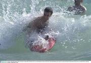 23 October 2003; Dessie Dolan makes an attempt at surfing while swimming in the sea at Cottesloe Beach, in advance of the Foster's International Rules game  between Australia and Ireland. Cottesloe Beach, Perth, Western Australia. Picture credit; Ray McManus / SPORTSFILE *EDI*