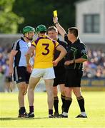 15 June 2013; Referee Brian Gavin, right, with linesman Barry Kelly by his side issues a yellow card to Tomas Waters, Wexford, and Conor McCormack, Dublin. Leinster GAA Hurling Senior Championship Quarter-Final Replay, Dublin v Wexford, Parnell Park, Dublin. Picture credit: Ray McManus / SPORTSFILE