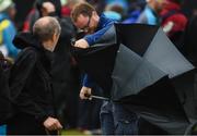 17 July 2019; A spectator has trouble with his umbrella during a practice round ahead of the 148th Open Championship at Royal Portrush in Portrush, Co. Antrim. Photo by Ramsey Cardy/Sportsfile