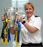 16 August 2019; Val Butterly, Airport Search Unit, Dublin Airport, with the Liam MacCarthy Cup at the GAA’s Home for the Match stand in the arrivals hall at Dublin Airport. Photo by Ramsey Cardy/Sportsfile
