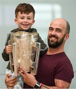 16 August 2019; Johnny Kelly, with his 6 year old son Archie, from Mooncoin, Kilkenny, with the Liam MacCarthy Cup at the GAA’s Home for the Match stand in the arrivals hall at Dublin Airport. Photo by Ramsey Cardy/Sportsfile