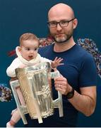 16 August 2019; Neil Curran, with his daughter Rania, with the Liam MacCarthy Cup at the GAA’s Home for the Match stand in the arrivals hall at Dublin Airport. Photo by Ramsey Cardy/Sportsfile