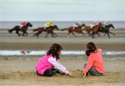 11 September 2019; Young racegoers Kristina McConnell, age 8, and sister Ella, age 5, from Laytown, play in the sand as horses go by during the Laytown Strand Races in Laytown, Co Meath. Photo by Seb Daly/Sportsfile