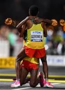 5 October 2019; Lelisa Desisa of Ethiopia, hidden, is helped to his feet by team-mate Mosinet Geremew after winning the Men's Marathon during day nine of the 17th IAAF World Athletics Championships Doha 2019 at the Corniche in Doha, Qatar. Photo by Sam Barnes/Sportsfile