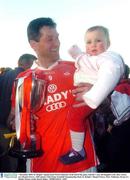 7 December 2003; St. Brigids' captain Jason Ward celebrates at the end of the game, with his 1 year old daughter Erin, after victory over Round Towers. AIB Leinster Club Senior Football Championship Final, St. Brigids v Round Towers, Pairc Tailteann, Navan, Co. Meath. Picture credit; David Maher / SPORTSFILE *EDI*