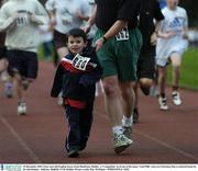 25 December 2003; Four-year-old Eoghan Joyce, from Dundrum, Dublin,  a 'Compeditor' in of one of the many 'Goal Mile' races on Christmas Day is ushered home by his dad Rodney. Athletics. Belfield, UCD, Dublin. Picture credit; Ray McManus / SPORTSFILE *EDI*