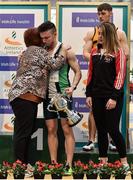 1 March 2020;  Dean Adams of Ballymena and Antrim AC is presented with the Craig Lynch cup by Craig's mother Anne Lynch, left, and fiancé Amy Cotter, right, after winning the Senior Men's 60m event during Day Two of the Irish Life Health National Senior Indoor Athletics Championships at the National Indoor Arena in Abbotstown in Dublin. Photo by Sam Barnes/Sportsfile