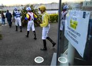 13 March 2020; A view of an advisory sign regarding Coronavirus (COVID-19) as jockeys make their way to the parade ring prior to the View Restaurant At Dundalk Stadium Claiming Race at Dundalk Stadium in Co Louth. Photo by Seb Daly/Sportsfile