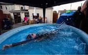 29 April 2020; Swimmer Mia Whelan-O'Connor of ESB Swimming Club swims in her back garden in an inflatable pool, in Inchicore, Dublin, using a swimming parachute and a bungee cord with the assistance of her Dad Michael and Mother Carol. Photo by Ramsey Cardy/Sportsfile