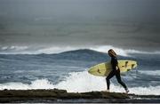 26 May 2020; A surfer makes her way out to the sea along the rocks at Lahinch in Clare. Photo by Seb Daly/Sportsfile