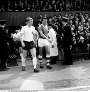 24 May 1964; England captain Bobby Moore, West Ham United, left, and Republic of Ireland captain Noel Cantwell, Manchester United, lead their respective sides out ahead of the match. International Friendly, Republic of Ireland v England, Dalymount Park, Dublin. Photo by Connelly Collection/Sportsfile