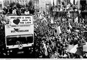 1 July 1990; The Republic of Ireland squad are cheered by supporters as they are brought by open top bus from Dublin Airport to College Green in Dublin city centre on their arrival home for a homecoming reception after their participation in the 1990 FIFA World Cup Finals in Italy. Photo by Ray McManus/Sportsfile