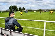 19 July 2020; A spectator wearing a face covering watches on during the Leinster Senior League Senior Sunday Division match between Bluebell United and Ballymun United at Capco Park in Bluebell, Dublin.  Photo by Sam Barnes/Sportsfile