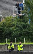 26 July 2020; Toomevara supporters Paddy Shanahan, left, and Séamus O'Meara look on from a cherrypicker outside the ground as Gardaí Richie Kennedy, left, and Darren Owens look on during the Tipperary County Senior Hurling Championship Group 4 Round 1 match between Toomevara and Borris-Ileigh at McDonagh Park in Nenagh, Tipperary. GAA matches continue to take place in front of a limited number of people in an effort to contain the spread of the Coronavirus (COVID-19) pandemic. Photo by Piaras Ó Mídheach/Sportsfile