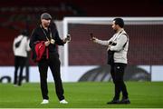 29 October 2020; Dundalk interim head coach Filippo Giovagnoli, left, and assistant coach Giuseppe Rossi on their mobile phones as they walk the pitch prior to the UEFA Europa League Group B match between Arsenal and Dundalk at the Emirates Stadium in London, England. Photo by Ben McShane/Sportsfile