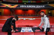 29 October 2020; Darragh Walsh, left, and team videographer Shane Taaffe hang out a banner in commemoration to the late Dundalk team videographer Harry Taaffe prior to the UEFA Europa League Group B match between Arsenal and Dundalk at the Emirates Stadium in London, England. Photo by Ben McShane/Sportsfile