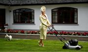 30 July 2020; Louise Allen from Slane in Meath, and her dog Sambo, cuts the grass in her outfit for the 2020 Galway Races Ladies’ Day, which has now had to go virtual / online due to horse racing continuing behind closed doors on the advice of the Irish Government in an effort to contain the spread of the Coronavirus. Photo by Harry Murphy/Sportsfile