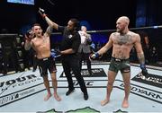24 January 2021; Dustin Poirier, left, has his hand raised by referee Herb Dean after defeating Conor McGregor in the second round of their UFC 257 Lightweight bout at the Etihad Arena in Abu Dhabi, United Arab Emirates. Photo by Jeff Bottari/Zuffa LLC/Getty Images via Sportsfile