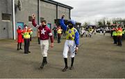 20 March 2021; Jockeys Jack Kennedy, left, and Rachael Blackmore makes their way to the parade ring through a guard of honour from fellow jockeys and course staff, following their successes at the Cheltenham Racing Festival, before the Leugh Handicap Hurdle at Thurles Racecourse in Tipperary. Photo by Seb Daly/Sportsfile