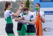 11 April 2021; Aifric Keogh of Ireland, left, gives Emily Hegarty her silver medal as Eimear Lambe and Fiona Murtagh look on after the Women's Four A Final during Day 3 of the European Rowing Championships 2021 at Varese in Italy. Photo by Roberto Bregani/Sportsfile