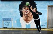 12 April 2021; Dublin artist Chelsea Jacobs immitates the famous 'hand of God' in front of her mural depicting the late Argentine footballer Diego Maradona at Havelock Square in Dublin. Photo by David Fitzgerald/Sportsfile