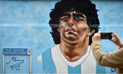 12 April 2021; A passer-by takes a photo of a mural by Dublin artist Chelsea Jacobs depicting the late Argentine footballer Diego Maradona at Havelock Square in Dublin. Photo by David Fitzgerald/Sportsfile