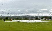 21 May 2021; Covers are seen on the pitch through the window of the media room as rain delays the start of play before the Cricket Ireland InterProvincial Cup 2021 match between North West Warriors and Northern Knights at Bready Cricket Club in Magheramason, Tyrone. Photo by Sam Barnes/Sportsfile