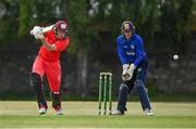19 June 2021; Jack Carty of Munster Reds plays a shot, watched by North West Warriors' wicketkeeper Stephen Doheny during the Cricket Ireland InterProvincial Trophy 2021 match between Munster Reds and North West Warriors at Pembroke Cricket Club in Dublin. Photo by Seb Daly/Sportsfile