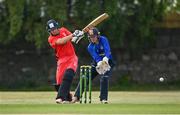 19 June 2021; PJ Moor of Munster Reds plays a shot, watched by North West Warriors' wicketkeeper Stephen Doheny during the Cricket Ireland InterProvincial Trophy 2021 match between Munster Reds and North West Warriors at Pembroke Cricket Club in Dublin. Photo by Seb Daly/Sportsfile