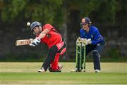 19 June 2021; Matt Ford of Munster Reds plays a shot to score a six, watched by North West Warriors' wicketkeeper Stephen Doheny, during the Cricket Ireland InterProvincial Trophy 2021 match between between Munster Reds and North West Warriors at Pembroke Cricket Club in Dublin. Photo by Seb Daly/Sportsfile