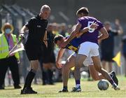 27 June 2021; Niall Donnelly of Wicklow is tackled by Brian Malone of Wexford, as linesman Cormac Reilly looks on, during the Leinster GAA Football Senior Championship Round 1 match between Wicklow and Wexford at County Grounds in Aughrim, Wicklow. Photo by Piaras Ó Mídheach/Sportsfile
