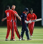 30 June 2021; Aaron Cawley of Munster Reds, second from left, is congratulated by team-mate Josh Manley after bowling out Neil Rock of Northern Knights during the Cricket Ireland InterProvincial Cup 2021 match between Northern Knights and Munster Reds at Bready Cricket Club in Stormont in Belfast. Photo by David Fitzgerald/Sportsfile