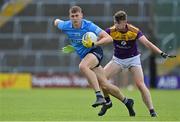 4 July 2021; Peadar Ó Cofaigh Byrne of Dublin is tackled by Niall Hughes of Wexford during the Leinster GAA Football Senior Championship Quarter-Final match between Wexford and Dublin at Chadwicks Wexford Park in Wexford. Photo by Brendan Moran/Sportsfile