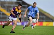 4 July 2021; Aaron Byrne of Dublin solos away from Eoin Porter of Wexford during the Leinster GAA Football Senior Championship Quarter-Final match between Wexford and Dublin at Chadwicks Wexford Park in Wexford. Photo by Brendan Moran/Sportsfile