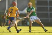 19 July 2021; Adam English of Limerick scores a point despite the attention of Mike Gough of Clare during the Munster GAA Hurling U20 Championship semi-final match between Limerick and Clare at the LIT Gaelic Grounds in Limerick. Photo by Ben McShane/Sportsfile