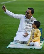 20 July 2021; Five year old Milhaan and dad Saad Ahmed take a picture on a smart phone on the pitch during the celebration of Eid Al-Adha at Croke Park in Dublin. Photo by Ray McManus/Sportsfile