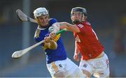 20 July 2021; John Campion of Tipperary scores a point despite the efforts of Daniel Hogan of Cork during the Munster GAA Hurling U20 Championship semi-final match between Tipperary and Cork at Semple Stadium in Thurles, Tipperary. Photo by Ben McShane/Sportsfile