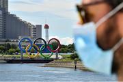 21 July 2021; A man wearing a face covering passes the Olympic Rings in the middle of the Tokyo Bay ahead of the start of the 2020 Tokyo Summer Olympic Games in Tokyo, Japan. Photo by Baptiste Fernandez/Sportsfile