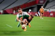 26 July 2021; Hugo Lennox of Ireland scores a try despite the tackle of Steve Tomasin of USA during the rugby sevens men's pool C match between Ireland and USA at the Tokyo Stadium during the 2020 Tokyo Summer Olympic Games in Tokyo, Japan. Photo by Stephen McCarthy/Sportsfile