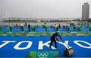 27 July 2021; A member of staff clears surface water from the track, as athletes arrive before the Women's Triathlon at the Odaiba Marine Park during the 2020 Tokyo Summer Olympic Games in Tokyo, Japan. Photo by Stephen McCarthy/Sportsfile
