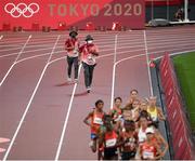 30 July 2021; Officials run to repair part of the track during round 1 of the women's 5000 metres at the Olympic Stadium during the 2020 Tokyo Summer Olympic Games in Tokyo, Japan. Photo by Stephen McCarthy/Sportsfile