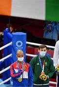 3 August 2021; Bronze medalist Aidan Walsh of Ireland, alongside gold medalist Roniel Iglesias of Cuba, looks up as the tri-colour is raised during men's welterweight division medal ceremony at the Kokugikan Arena during the 2020 Tokyo Summer Olympic Games in Tokyo, Japan. Photo by Brendan Moran/Sportsfile