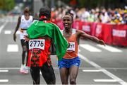 8 August 2021; Abdi Nageeye of Netherlands crosses the finish line in second place as he is greeted by first place Eliud Kipchoge of Kenya during the men's marathon at Sapporo Odori Park on day 16 during the 2020 Tokyo Summer Olympic Games in Sapporo, Japan. Photo by Ramsey Cardy/Sportsfile